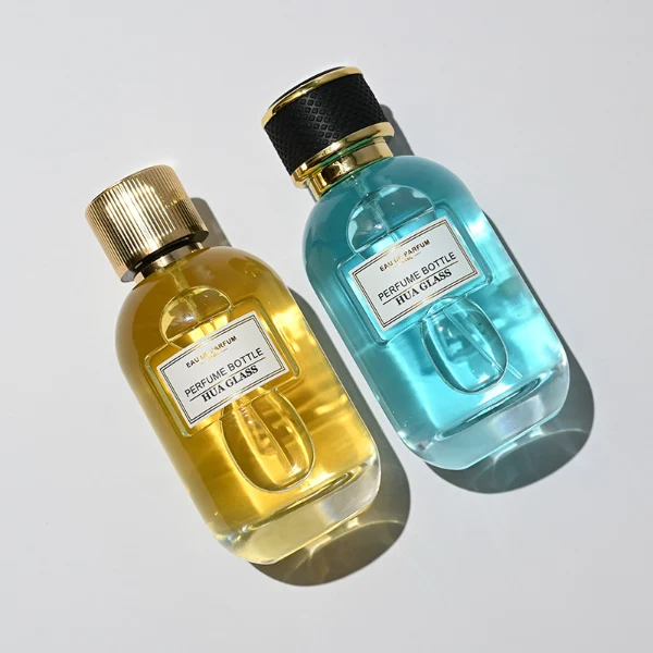 HUA0244 perfume bottle, cylindrical transparent glass body with thick base, 100 ml liquid, cylindrical plastic cap with exterior wrapped in leather or textured pattern, gold-colored bottle neck, brand label applied on bottle, modern luxurious design, ideal for gifting and daily use.