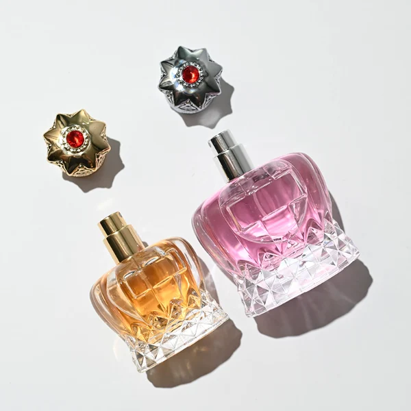 HUA0249 perfume bottle, faceted transparent glass body with thick base, 30 ml, 50 ml, or 100 ml liquid, ornate crown-shaped Zamac cap, brand label applied on bottle, luxurious ornate design, ideal for gifting and daily use.
