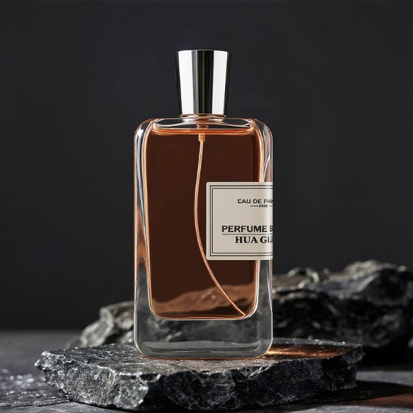 HUA0251 perfume bottle, rectangular transparent glass body with thick base, 100 ml liquid, cylindrical plastic cap with smooth high-gloss surface, flat top, straight uniform sides, tightly fitted to bottle neck, brand label applied on bottle, modern luxurious design, ideal for gifting and daily use.