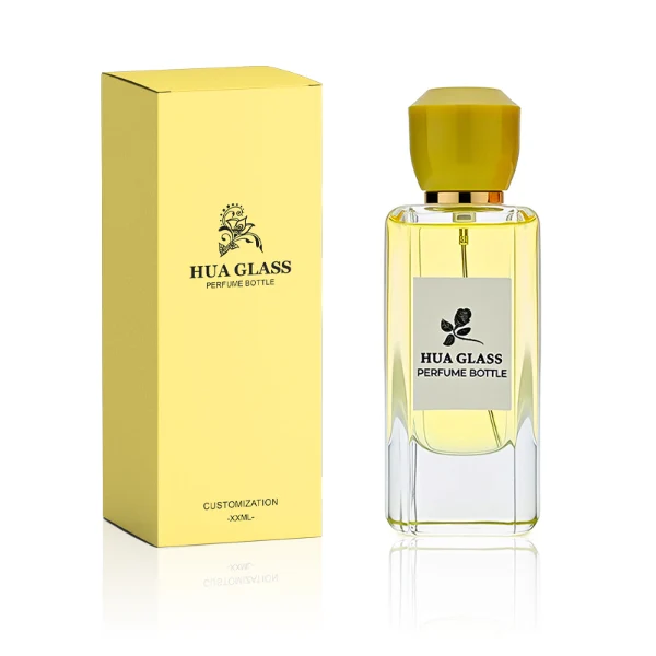 HUA0252 perfume bottle, rectangular transparent glass body with rounded edges and thick base, 50 ml or 80 ml liquid, yellow or red faceted geometric resin cap with smooth glossy finish, gold-colored bottle neck, brand label applied on bottle, modern artistic luxury design, ideal for gifting and daily use.
