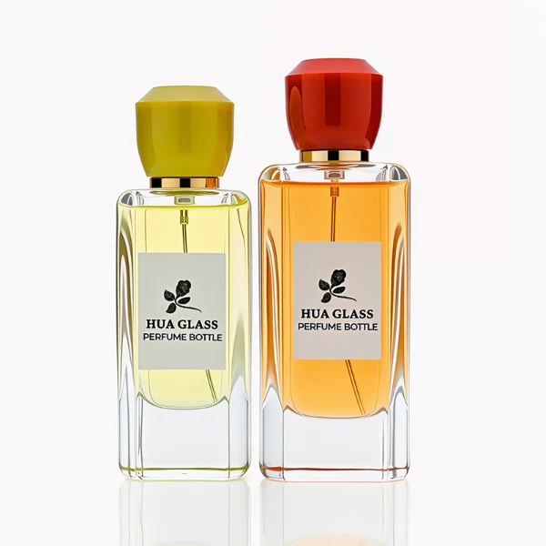 HUA0252 perfume bottle, rectangular transparent glass body with rounded edges and thick base, 50 ml or 80 ml liquid, yellow or red faceted geometric resin cap with smooth glossy finish, gold-colored bottle neck, brand label applied on bottle, modern artistic luxury design, ideal for gifting and daily use.