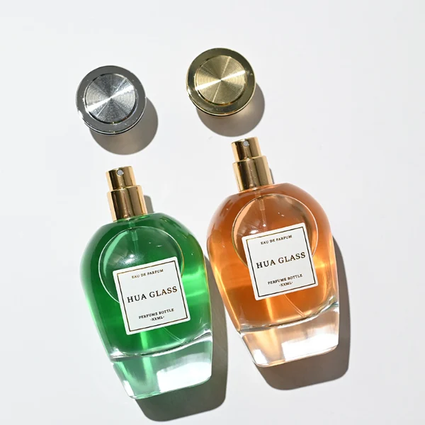 HUA0255 perfume bottle, rounded transparent glass body with soft curved silhouette and thick base, 100 ml liquid, flared Zamac cap with flat top and glossy finish, printed logo label, elegant luxury design, ideal for gifting and daily use.