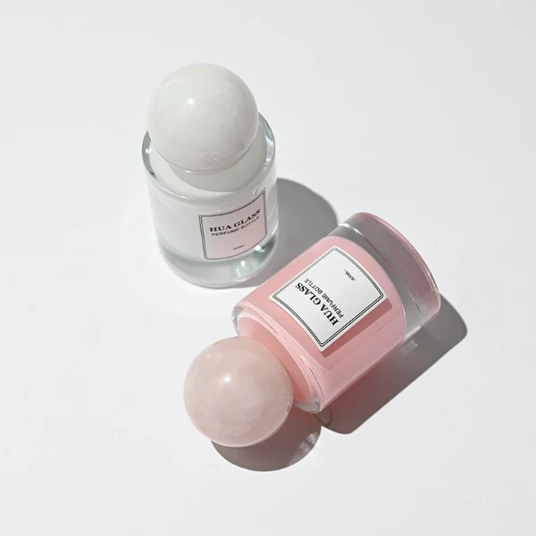 HUA0258 perfume bottle, internally sprayed cylindrical glass body with thick rounded base, 30 ml, 50 ml, or 100 ml liquid, oversized spherical plastic cap with glossy finish matching the internal spray glass color, customizable color design, printed logo label, modern minimalist luxury style, ideal for gifting and daily use.