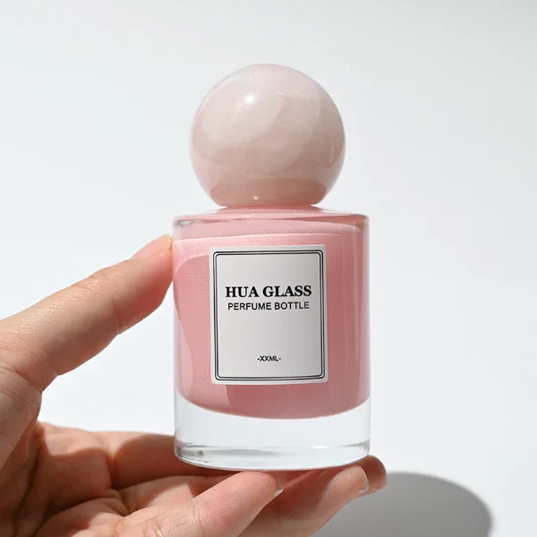 HUA0258 perfume bottle, internally sprayed cylindrical glass body with thick rounded base, 30 ml, 50 ml, or 100 ml liquid, oversized spherical plastic cap with glossy finish matching the internal spray glass color, customizable color design, printed logo label, modern minimalist luxury style, ideal for gifting and daily use.