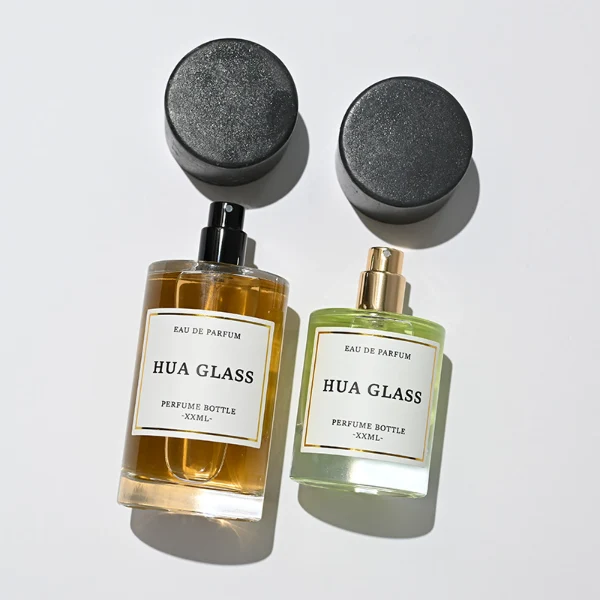 HUA0262 perfume bottle, cylindrical transparent glass body with thick rounded base, 30 ml, 50 ml, or 100 ml liquid, oversized flat cylindrical artificial stone cap with matte texture, printed logo label, modern minimalist luxury design, ideal for gifting and daily use.