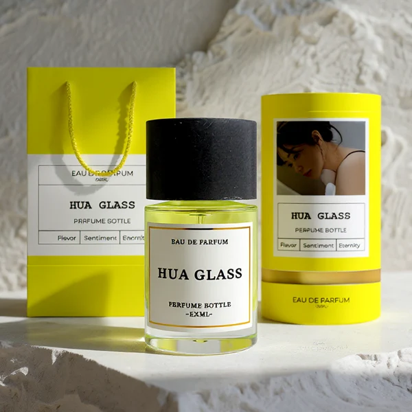 HUA0262 perfume bottle, cylindrical transparent glass body with thick rounded base, 30 ml, 50 ml, or 100 ml liquid, oversized flat cylindrical artificial stone cap with matte texture, printed logo label, modern minimalist luxury design, ideal for gifting and daily use.