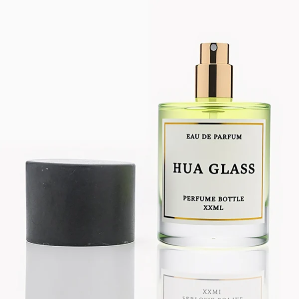 HUA0262 perfume bottle, cylindrical transparent glass body with thick rounded base, 30 ml, 50 ml, or 100 ml liquid, oversized flat cylindrical artificial stone cap with matte texture, printed logo label, modern minimalist luxury design, ideal for gifting and daily use.