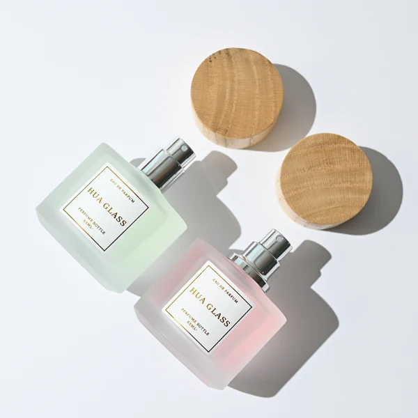 HUA0263 perfume bottle, frosted cylindrical glass body with thick rounded base, 30 ml, 50 ml, or 100 ml liquid, flat cylindrical bamboo cap with natural wood grain texture and silver bottle neck, printed logo label, natural minimalist luxury design, ideal for gifting and daily use.
