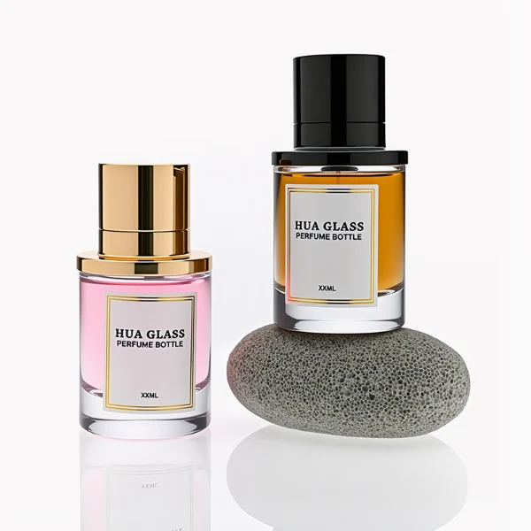 HUA0264 perfume bottle, cylindrical transparent glass body with thick rounded base, 50 ml or 100 ml liquid, stamp-shaped aluminum and magnet cap with glossy black or gold finish, printed logo label, modern luxury minimalist design, ideal for gifting and daily use.