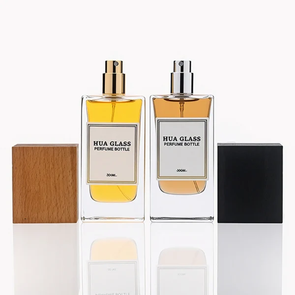 HUA0265 perfume bottle, rectangular transparent glass body with thick weighted base and rounded vertical edges, 30 ml, 50 ml, or 100 ml liquid, oversized rectangular plastic cap in wood-grain brown or matte black finish, printed logo label, modern minimalist luxury design, ideal for gifting and daily use.