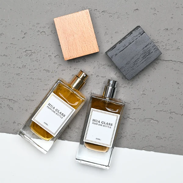 HUA0265 perfume bottle, rectangular transparent glass body with thick weighted base and rounded vertical edges, 30 ml, 50 ml, or 100 ml liquid, oversized rectangular plastic cap in wood-grain brown or matte black finish, printed logo label, modern minimalist luxury design, ideal for gifting and daily use.