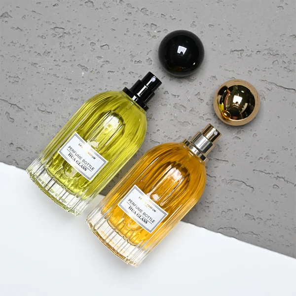 HUA0271 perfume bottle, cylindrical transparent glass body with vertical fluted texture and thick rounded base, 100 ml liquid, oversized spherical magnetic cap with glossy black or gold mirror finish, printed logo label, vintage luxury elegance design, ideal for gifting and daily use.