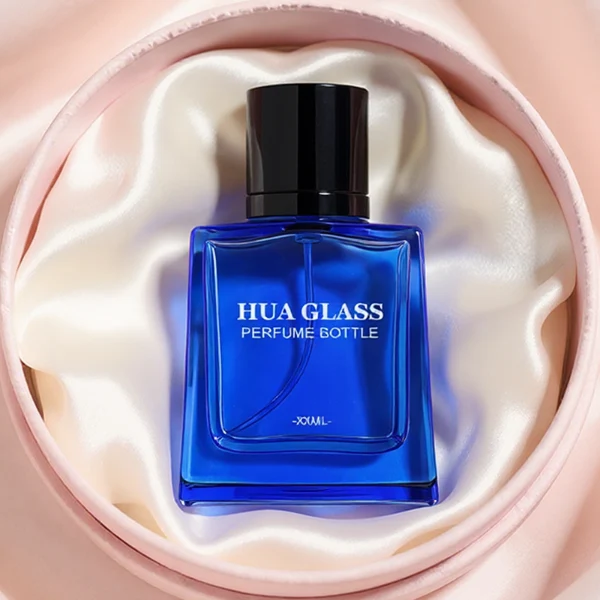 HUA0272 perfume bottle, semi-transparent blue or amber rectangular glass body with beveled edges and thick base, 35 ml, 50 ml, or 100 ml liquid, glossy cylindrical aluminum magnetic cap in gold or black, custom printed logo on bottle surface, modern luxury fashion design, ideal for gifting and daily use.