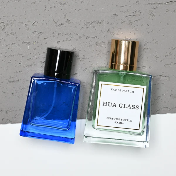 HUA0272 perfume bottle, semi-transparent blue or amber rectangular glass body with beveled edges and thick base, 35 ml, 50 ml, or 100 ml liquid, glossy cylindrical aluminum magnetic cap in gold or black, custom printed logo on bottle surface, modern luxury fashion design, ideal for gifting and daily use.