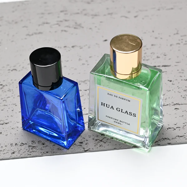 HUA0272 perfume bottle, semi-transparent blue or amber rectangular glass body with beveled edges and thick base, 35 ml, 50 ml, or 100 ml liquid, glossy cylindrical aluminum magnetic cap in gold or black, custom printed logo on bottle surface, modern luxury fashion design, ideal for gifting and daily use.