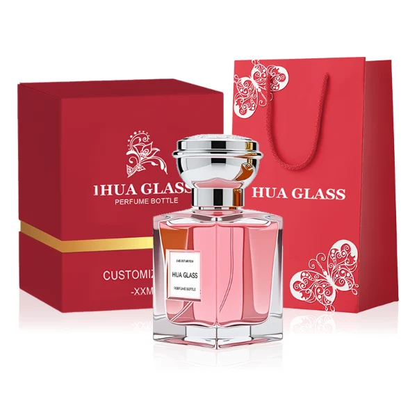 HUA0273 perfume bottle, transparent rectangular glass body with beveled edges and thick base, 50 ml or 100 ml liquid, glossy bowl-shaped plastic cap in silver or gold with matching bottle neck, brand label attached on bottle surface, modern elegant luxury design, ideal for gifting and daily use.