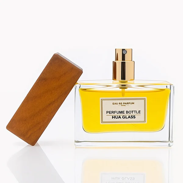 HUA0277 perfume bottle, transparent colorless rectangular glass body with thick base and straight edges, 30 ml, 50 ml, or 100 ml liquid, wide flat rectangular wooden cap in black or natural wood finish with gold bottle neck, printed label attached on bottle surface, modern minimalist luxury design, ideal for gifting and daily use.