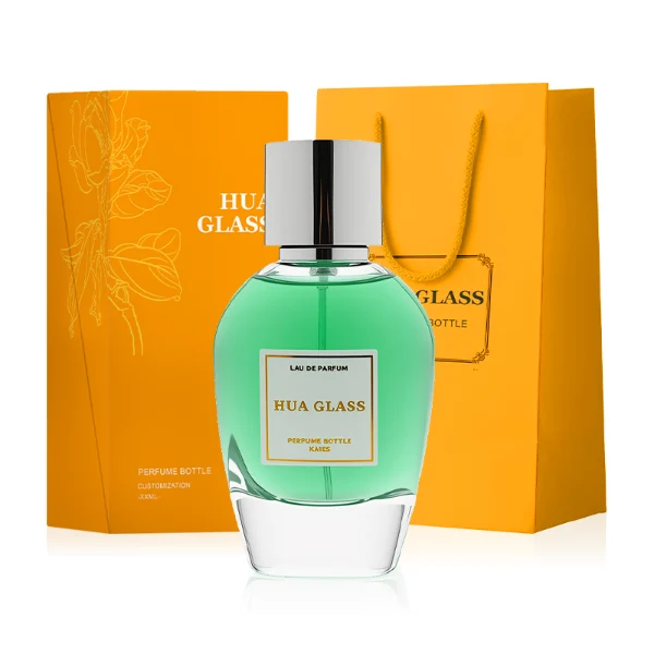 HUA0282 perfume bottle, rounded transparent glass body with thick clear base and customizable transparent colors, 100 ml liquid, glossy cylindrical Zamac cap in silver or gold finish with matching bottle neck, gold-bordered label attached on bottle surface, modern elegant luxury design, ideal for gifting and daily use.