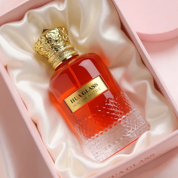HUA0283 perfume bottle, cylindrical transparent colorless glass body with embossed textured lower section, 100 ml liquid, ornate crown-shaped glossy gold Zamac cap, gold label attached on bottle surface, vintage luxurious fashion design, ideal for gifting and daily use.