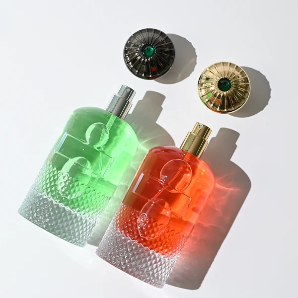HUA0283 perfume bottle, cylindrical transparent colorless glass body with embossed textured lower section, 100 ml liquid, ornate crown-shaped glossy gold Zamac cap, gold label attached on bottle surface, vintage luxurious fashion design, ideal for gifting and daily use.