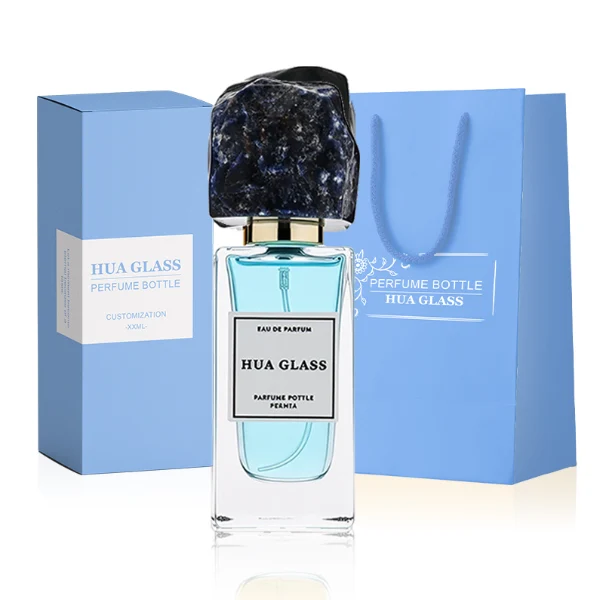 HUA0286 perfume bottle, rectangular transparent colorless glass body with thick base and beveled edges, 30 ml, 50 ml, or 100 ml liquid, irregular natural stone cap with raw textured surface and gold bottle neck, printed label attached on bottle surface, modern artistic luxury design, ideal for gifting and daily use.