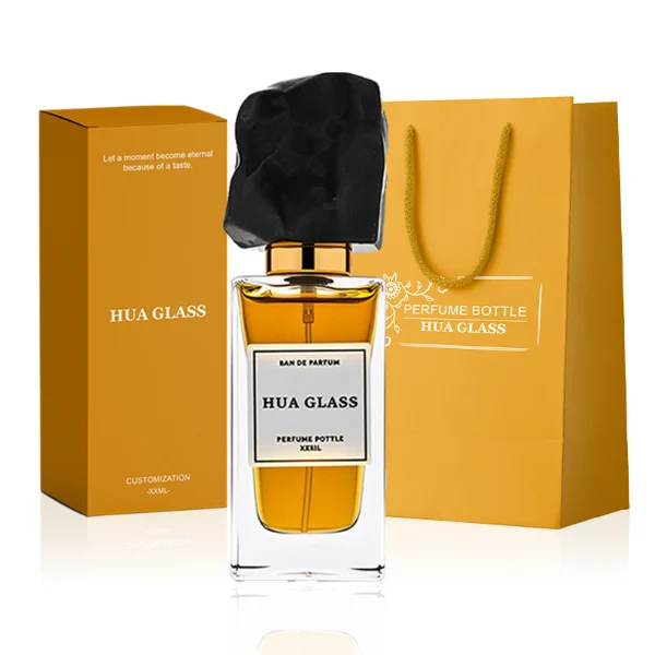 HUA0286 perfume bottle, rectangular transparent colorless glass body with thick base and beveled edges, 30 ml, 50 ml, or 100 ml liquid, irregular natural stone cap with raw textured surface and gold bottle neck, printed label attached on bottle surface, modern artistic luxury design, ideal for gifting and daily use.