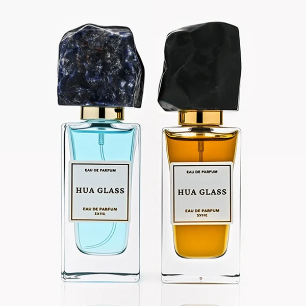 HUA0286 perfume bottle, rectangular transparent colorless glass body with thick base and beveled edges, 30 ml, 50 ml, or 100 ml liquid, irregular natural stone cap with raw textured surface and gold bottle neck, printed label attached on bottle surface, modern artistic luxury design, ideal for gifting and daily use.