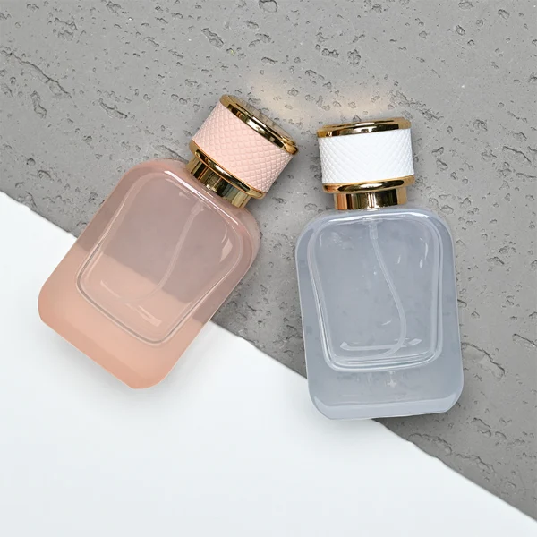 HUA0288 perfume bottle, rounded rectangular transparent or customizable semi-transparent glass body with thick base, 30 ml, 50 ml, or 100 ml liquid, cylindrical gold plastic cap wrapped with mesh-textured leather and gold bottle neck, gold printed logo on bottle surface, modern luxurious fashion design, ideal for gifting and daily use.
