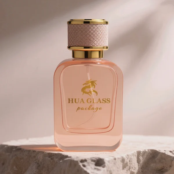 HUA0288 perfume bottle, rounded rectangular transparent or customizable semi-transparent glass body with thick base, 30 ml, 50 ml, or 100 ml liquid, cylindrical gold plastic cap wrapped with mesh-textured leather and gold bottle neck, gold printed logo on bottle surface, modern luxurious fashion design, ideal for gifting and daily use.