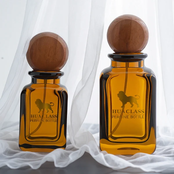 HUA0290 perfume bottle, rounded rectangular semi-transparent amber glass body with thick base and smooth edges, 30 ml, 50 ml, or 100 ml liquid, flattened spherical wooden cap with natural wood texture, gold printed logo on bottle surface, modern vintage luxury design, ideal for gifting and daily use.
