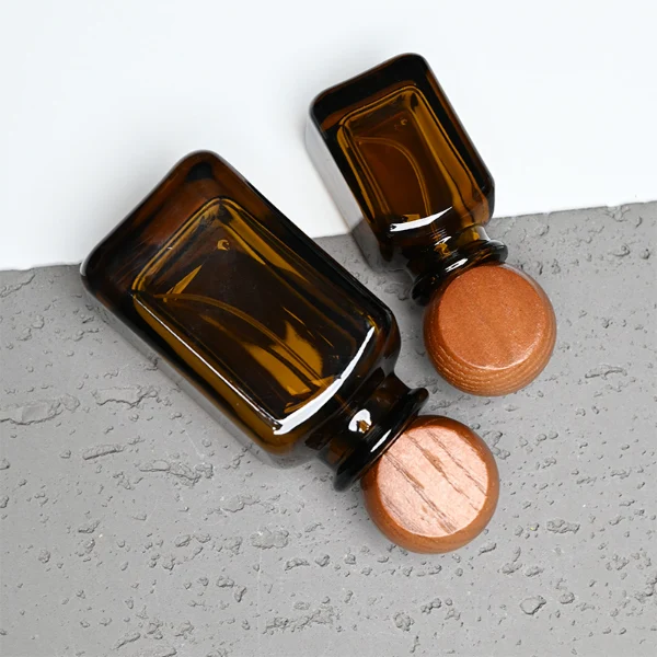 HUA0290 perfume bottle, rounded rectangular semi-transparent amber glass body with thick base and smooth edges, 30 ml, 50 ml, or 100 ml liquid, flattened spherical wooden cap with natural wood texture, gold printed logo on bottle surface, modern vintage luxury design, ideal for gifting and daily use.