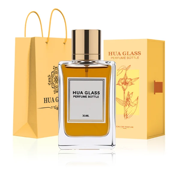 HUA0291 perfume bottle, rectangular transparent colorless glass body with thick base and beveled edges, 100 ml liquid, glossy cylindrical aluminum cap in gold or black finish, printed label attached on bottle surface, modern minimalist luxury design, ideal for gifting and daily use.