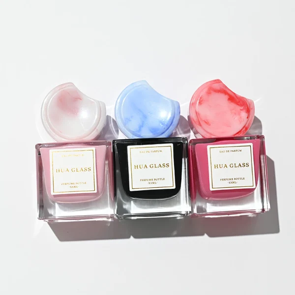 HUA0293 perfume bottle, square internally sprayed glass body with thick base and customizable colors, 30 ml, 50 ml, or 100 ml liquid, flattened crescent-shaped resin cap in customizable colors, printed label attached on bottle surface, modern playful luxury design, ideal for gifting and daily use.
