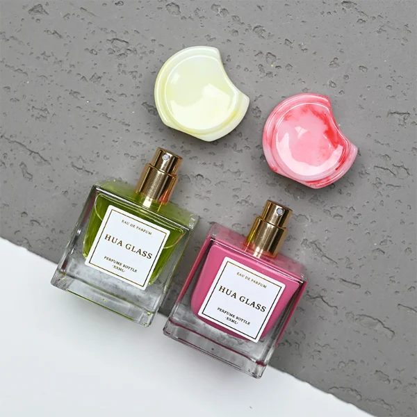 HUA0293 perfume bottle, square internally sprayed glass body with thick base and customizable colors, 30 ml, 50 ml, or 100 ml liquid, flattened crescent-shaped resin cap in customizable colors, printed label attached on bottle surface, modern playful luxury design, ideal for gifting and daily use.