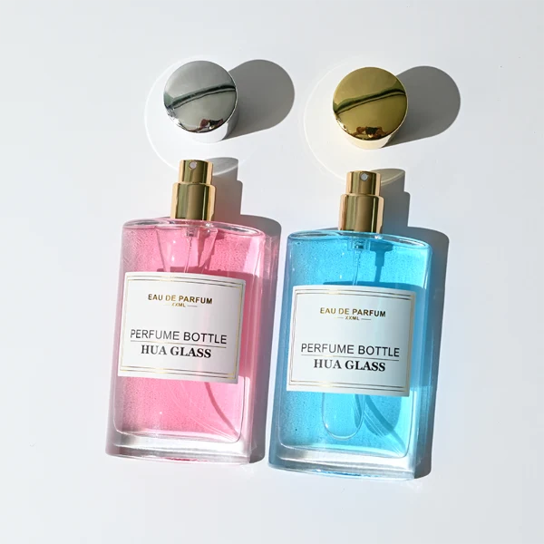 HUA0295 perfume bottle, rectangular handbag-shaped transparent colorless glass body with rounded corners and thick base, 50 ml liquid, glossy tapered cylindrical plastic cap in gold or silver finish, printed label attached on bottle surface, modern elegant luxury design, ideal for gifting and daily use.