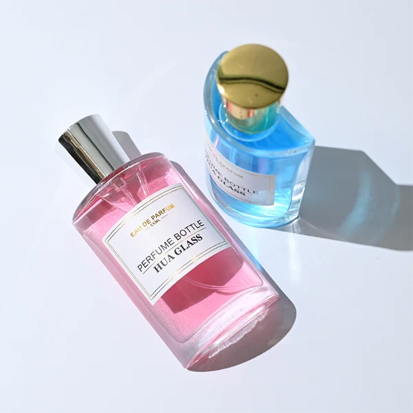 HUA0295 perfume bottle, rectangular handbag-shaped transparent colorless glass body with rounded corners and thick base, 50 ml liquid, glossy tapered cylindrical plastic cap in gold or silver finish, printed label attached on bottle surface, modern elegant luxury design, ideal for gifting and daily use.