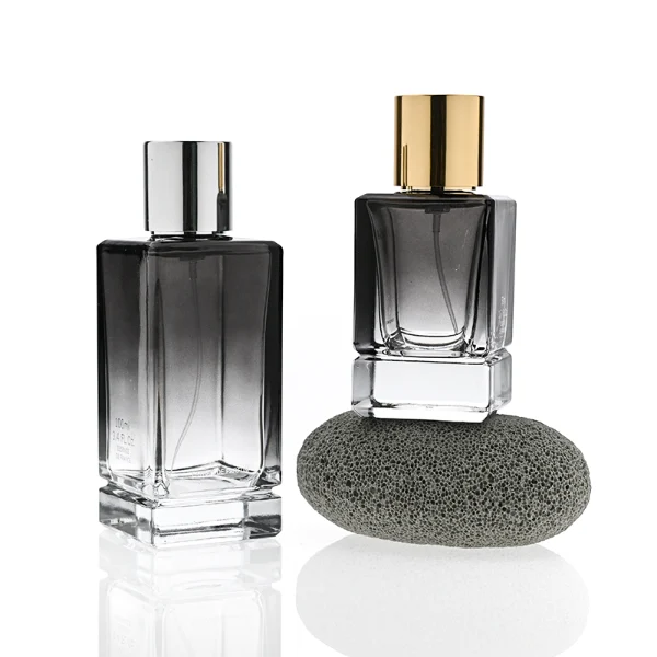 HUA0298 perfume bottle, gradient semi-transparent glass body with thick base and curved side contours, 30 ml, 50 ml, or 100 ml liquid, glossy cylindrical aluminum cap in black, silver, or gold finish, printed logo on bottle surface, modern minimalist luxury design, ideal for gifting and daily use.