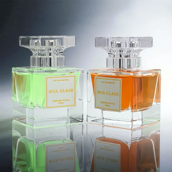 HUA0300 perfume bottle, rectangular transparent colorless glass body with thick base and smooth surface, 30 ml, 50 ml, or 100 ml liquid, flat multifaceted plastic cap with silver bottle neck, printed label attached on bottle surface, modern elegant luxury design, ideal for gifting and daily use.