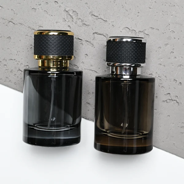 HUA0301 perfume bottle, semi-transparent black cylindrical glass body with thick base, 30 ml, 50 ml, or 100 ml liquid, black leather-wrapped plastic cap with gold or silver plastic bottle neck, gold or silver printed logo on bottle surface, modern masculine luxury design, ideal for gifting and daily use.