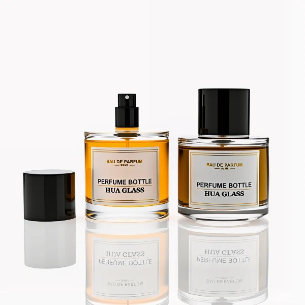 HUA0303 perfume bottle, cylindrical transparent colorless glass body with thick rounded base and smooth curved silhouette, 30 ml, 50 ml, or 100 ml liquid, glossy black cylindrical aluminum cap with flat top, printed label attached on bottle surface, modern minimalist luxury design, ideal for gifting and daily use.