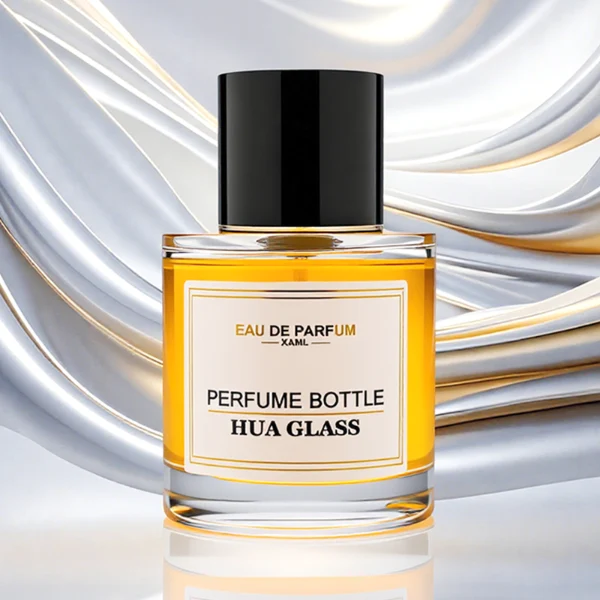 HUA0303 perfume bottle, cylindrical transparent colorless glass body with thick rounded base and smooth curved silhouette, 30 ml, 50 ml, or 100 ml liquid, glossy black cylindrical aluminum cap with flat top, printed label attached on bottle surface, modern minimalist luxury design, ideal for gifting and daily use.