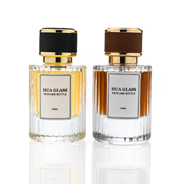 HUA0307 perfume bottle, cylindrical transparent colorless glass body with vertical ribbed texture and thick base, 30 ml, 50 ml, or 100 ml liquid, gold plastic cylindrical cap wrapped with black or brown leather, printed label attached on bottle surface, modern vintage luxury design, ideal for gifting and daily use.