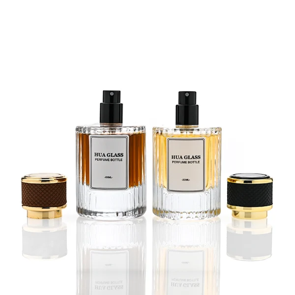 HUA0307 perfume bottle, cylindrical transparent colorless glass body with vertical ribbed texture and thick base, 30 ml, 50 ml, or 100 ml liquid, gold plastic cylindrical cap wrapped with black or brown leather, printed label attached on bottle surface, modern vintage luxury design, ideal for gifting and daily use.