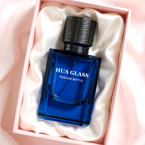 HUA0308 perfume bottle, semi-transparent blue or dark green customizable glass body with thick base and clean rectangular silhouette, 30 ml, 50 ml, or 100 ml liquid, textured cylindrical plastic cap in gold or black finish, gold or white printed logo on bottle surface, modern masculine luxury design, ideal for gifting and daily use.