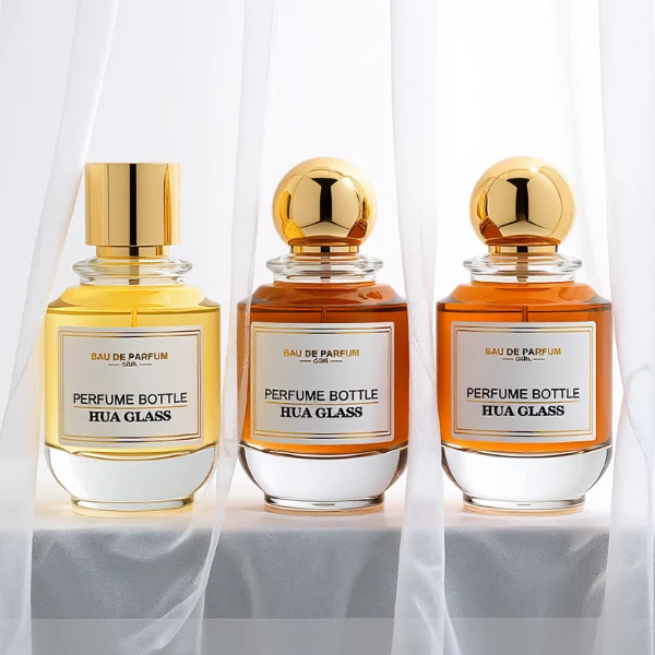 HUA0309 perfume bottle, rounded transparent colorless glass body with thick base and smooth curved silhouette, 100 ml liquid, glossy Zamac cap in cylindrical or spherical shape, printed label attached on bottle surface, elegant modern luxury design, ideal for gifting and daily use.