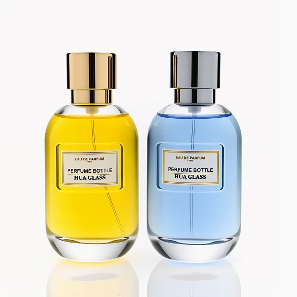HUA0310 perfume bottle, rounded transparent colorless glass body with thick base and smooth curved silhouette, 100 ml liquid, glossy cylindrical Zamac cap with matching gold or silver metallic gloss bottle neck, printed label attached on bottle surface, modern minimalist luxury design, ideal for gifting and daily use.