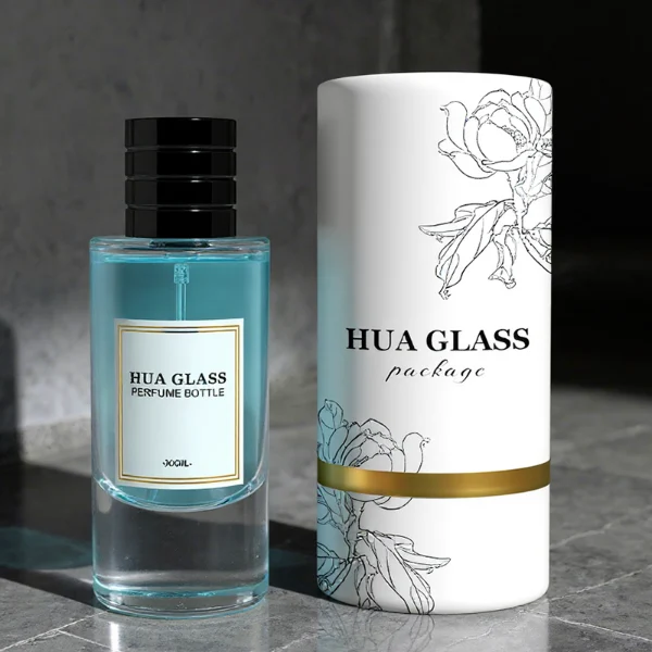 HUA0311 perfume bottle, cylindrical transparent colorless glass body with thick rounded base and smooth curved silhouette, 80 ml liquid, layered cylindrical plastic cap with ring groove details in gold or black finish, printed label attached on bottle surface, modern minimalist luxury design, ideal for gifting and daily use.