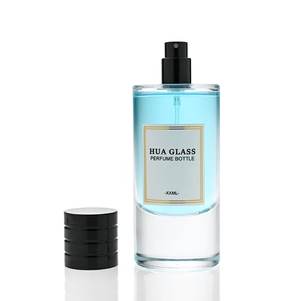 HUA0311 perfume bottle, cylindrical transparent colorless glass body with thick rounded base and smooth curved silhouette, 80 ml liquid, layered cylindrical plastic cap with ring groove details in gold or black finish, printed label attached on bottle surface, modern minimalist luxury design, ideal for gifting and daily use.