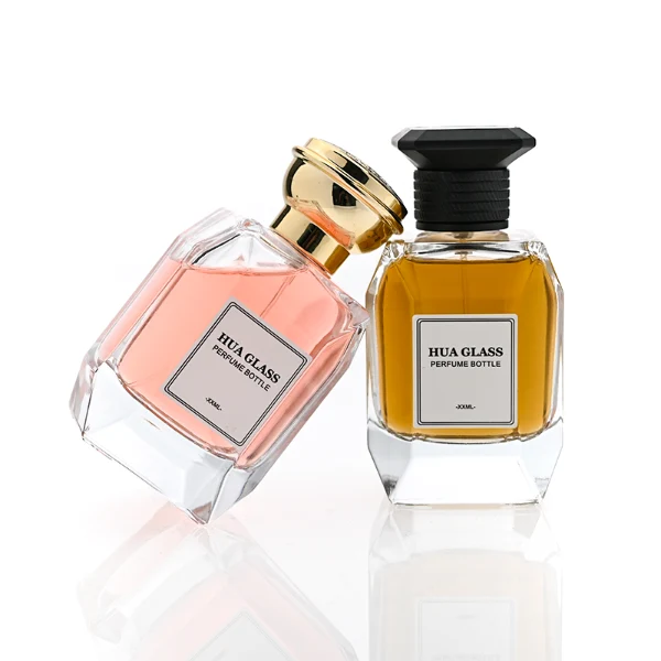 HUA0312 perfume bottle, transparent colorless multifaceted angular-cut glass body with thick geometric base, 100 ml liquid, multifaceted spherical or layered bowl-shaped plastic cap with gold bottle neck, printed label attached on bottle surface, elegant modern luxury design, ideal for gifting and daily use.