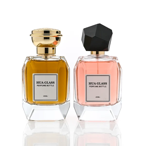 HUA0312 perfume bottle, transparent colorless multifaceted angular-cut glass body with thick geometric base, 100 ml liquid, multifaceted spherical or layered bowl-shaped plastic cap with gold bottle neck, printed label attached on bottle surface, elegant modern luxury design, ideal for gifting and daily use.